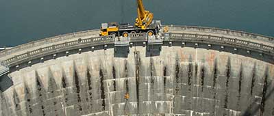 Crane lowering down a dam.